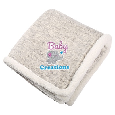 Tan and white sherpa blanket with embroidered design.