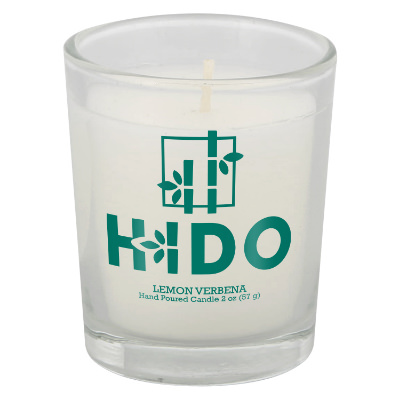 White glass candle with a branded logo.