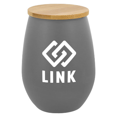 Gray glass candle with a personalized logo.
