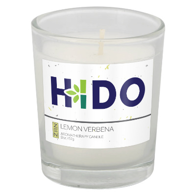 White glass candle with a branded logo.