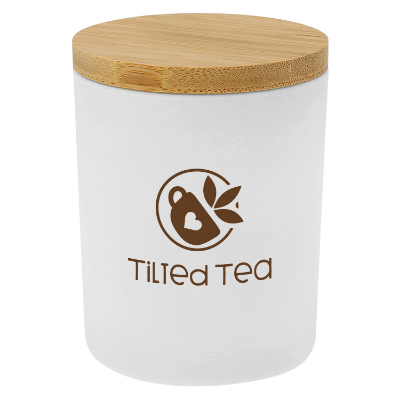 White glass candle with a branded logo.