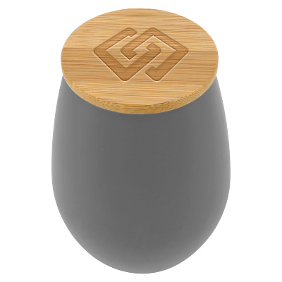 Gray glass candle with a personalized logo.